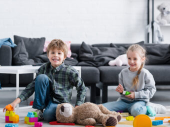 adorable happy children sitting on floor and playing with toys at home